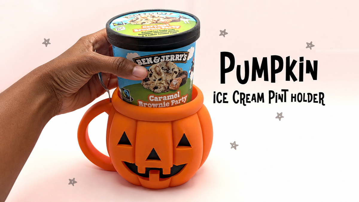Orange traditional jack-o'-lantern ice cream pint holder with triangle eyes, toothy smile and handle, shown with ice cream tub