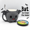 Dark gray bat ice cream pint holder with wings, fangs, handle and spoon rest pictured with an ice cream tub