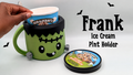 Green Frankenstein-inspired ice cream pint holder with black hair, stitched forehead, silver bolts and handle, shown with a pint tub