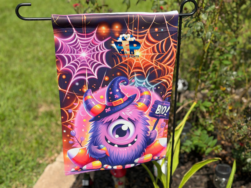 Mint green furry monster with potion, pumpkins and skull on a Halloween garden flag